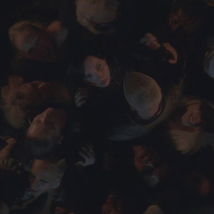 Seen from above, a crowd of faces packed close together in the dark around Kenya Grace